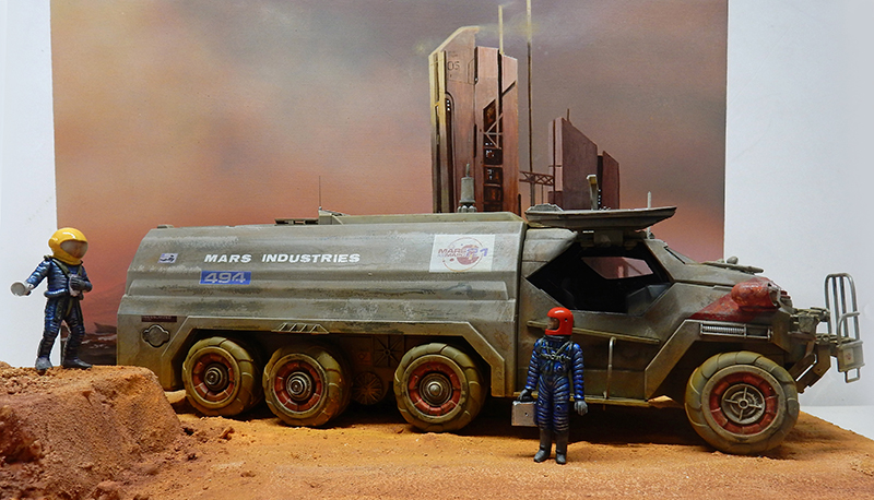 Maquette de véhicule blindé Mars Industries et deux astronautes sur sol martien devant une base