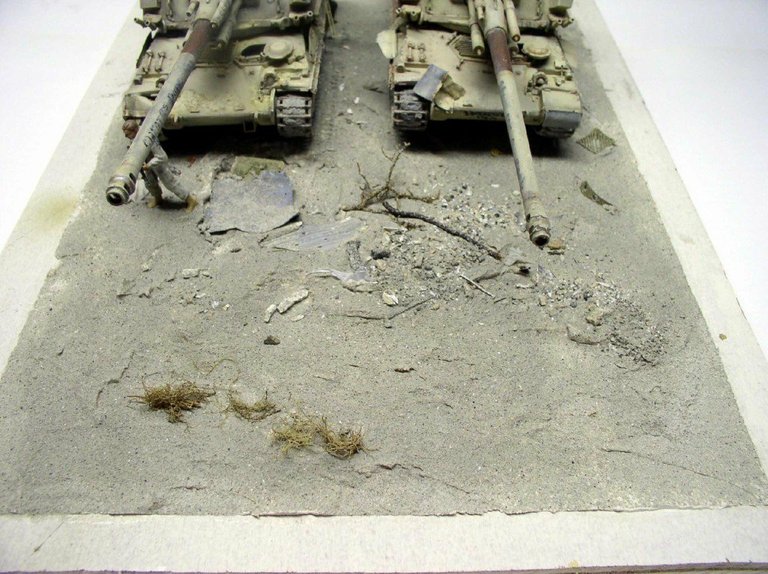 Deux maquettes d'automoteurs 155 AUF1 GCT sur un diorama de terrain sableux fissuré avec touffes d'herbe