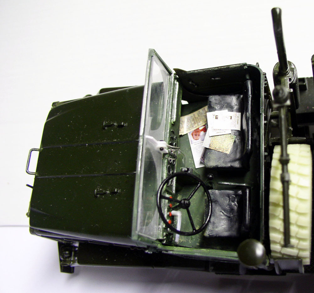 Vue plongeante sur la cabine ouverte de la maquette M923 avec volant, sièges et cartes