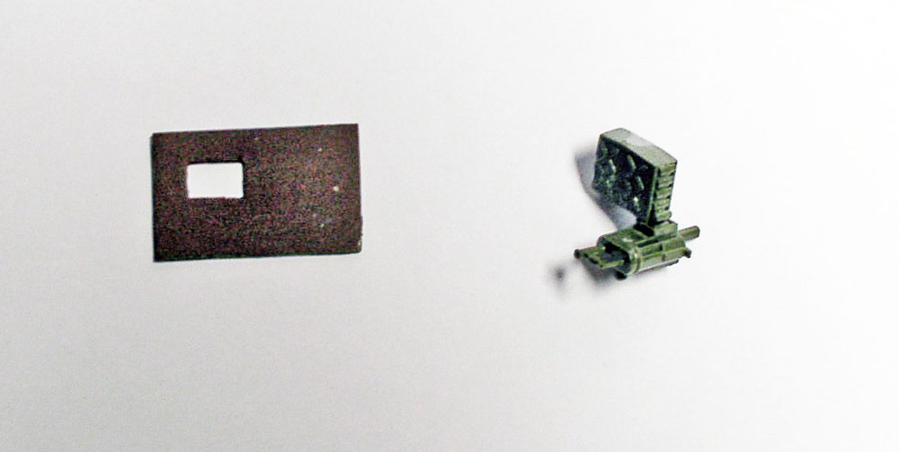 Petites pièces de maquette du M923 Big Foot peintes en vert et marron sur fond blanc