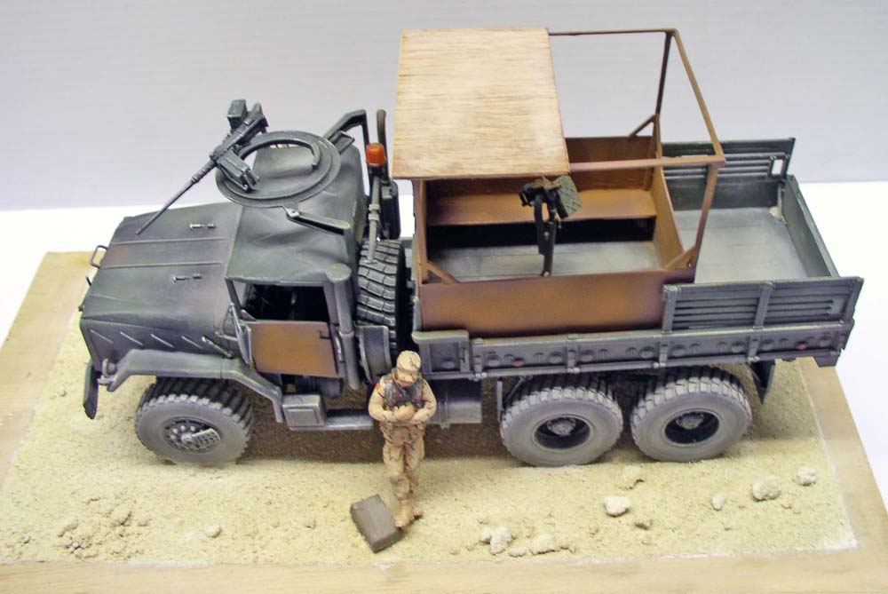 Maquette du camion militaire M923 Big Foot avec figurine de soldat sur diorama de sable