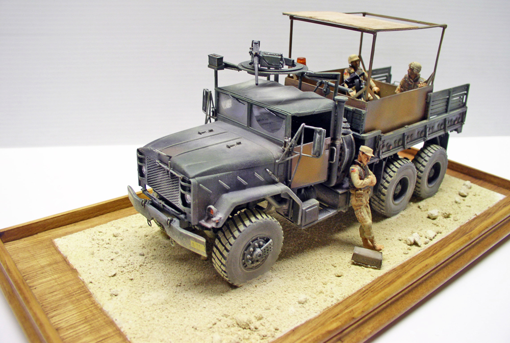 Maquette du camion militaire M923 Big Foot avec figurines de soldats sur diorama de sable