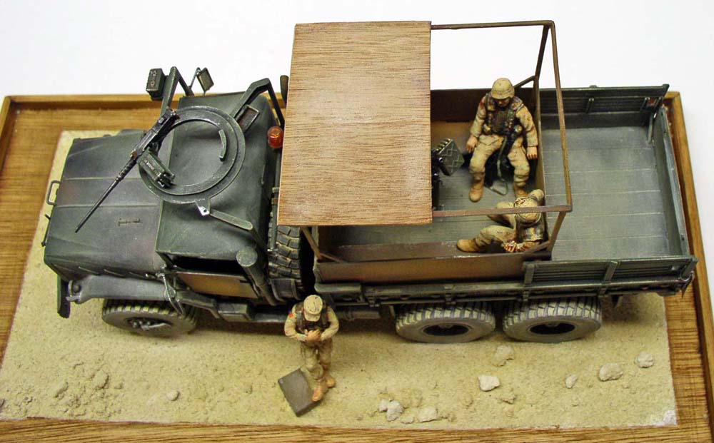 Maquette du camion militaire M923 avec mitrailleuse et figurines de soldats sur diorama désertique