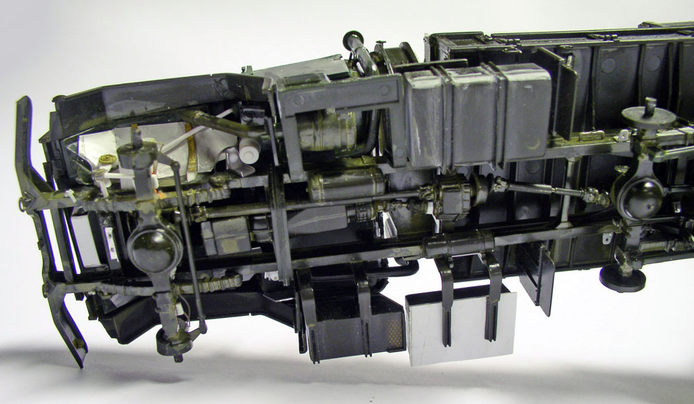 Vue du dessous du châssis de la maquette M923 Big Foot montrant essieux, transmission et réservoirs