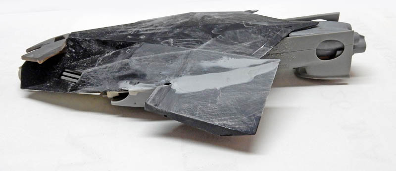 Maquette de vaisseau spatial en cours de montage avec mastic et ponçage du fuselage