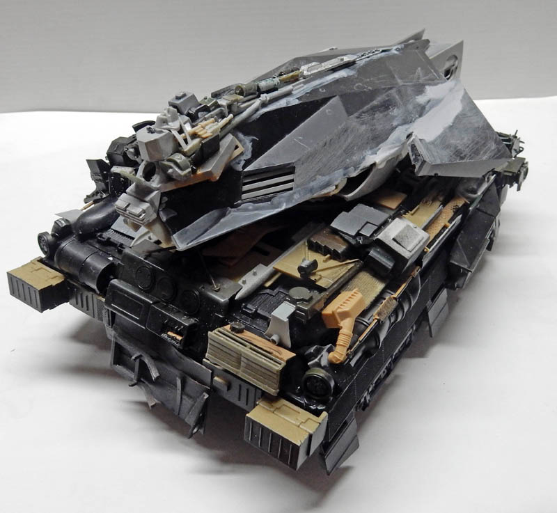 Maquette de véhicule blindé futuriste gris en cours d'assemblage avec détails sable
