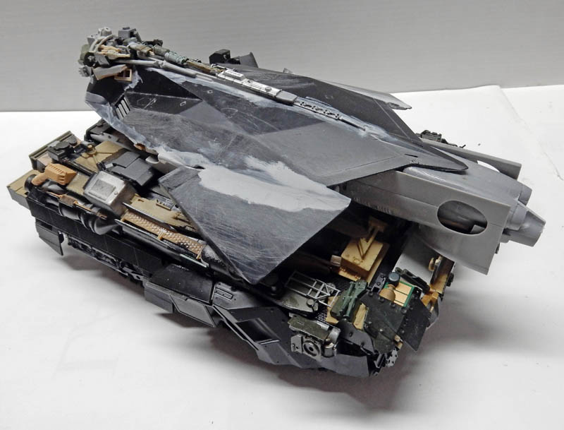 Maquette de véhicule blindé futuriste gris et noir en cours de construction détaillée