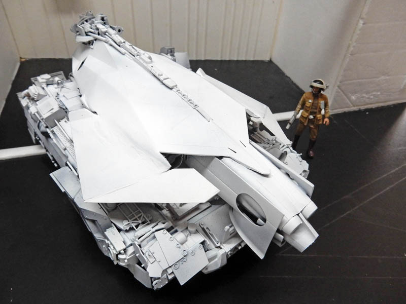 Maquette de véhicule blindé futuriste gris à facettes avec figurine de soldat à côté