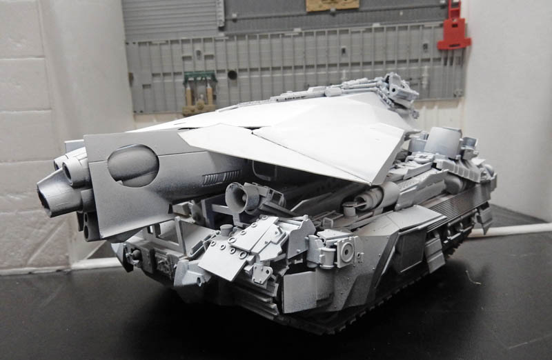 Maquette de véhicule blindé chenillé futuriste gris en cours d'assemblage, vue de face