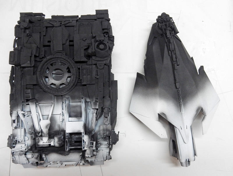 Deux pièces de maquette aux détails mécaniques peintes en dégradé du noir au gris clair