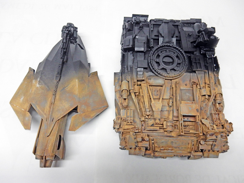 Deux pièces de maquette peintes effet rouille et métal, détails mécaniques, posées sur fond blanc