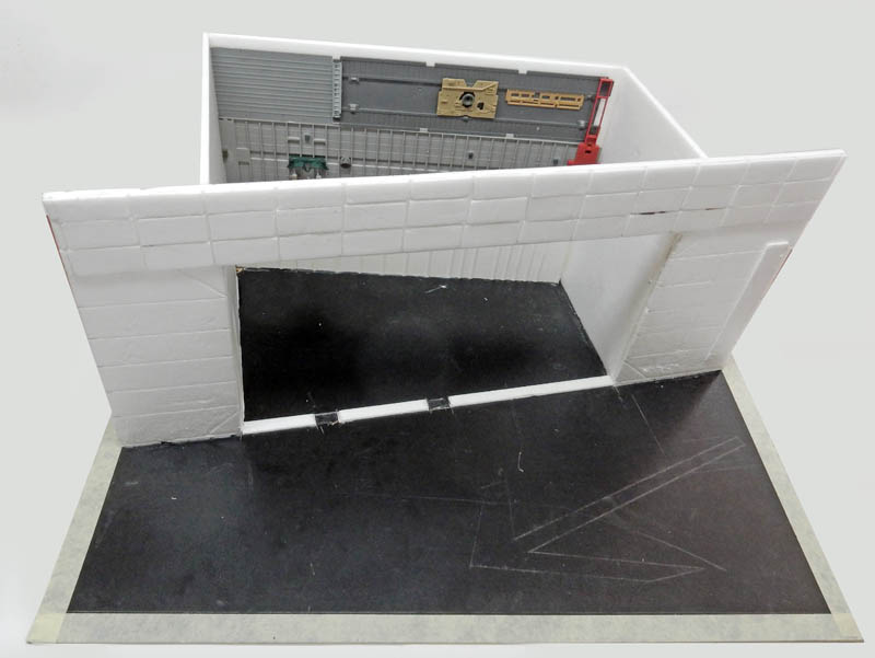 Maquette de bâtiment blanc avec large ouverture et sol noir en construction