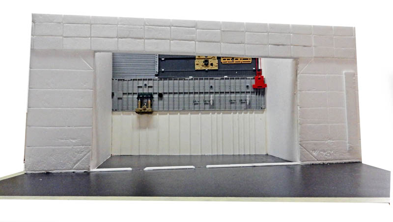 Maquette de bâtiment blanc avec grande ouverture montrant des éléments mécaniques gris et rouges