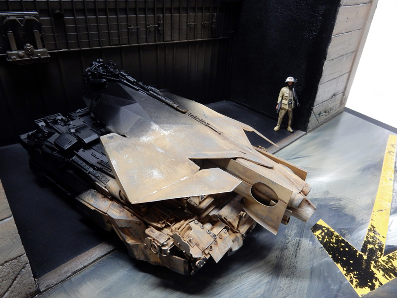 Maquette de véhicule blindé futuriste rouillé dans un hangar avec figurine de pilote