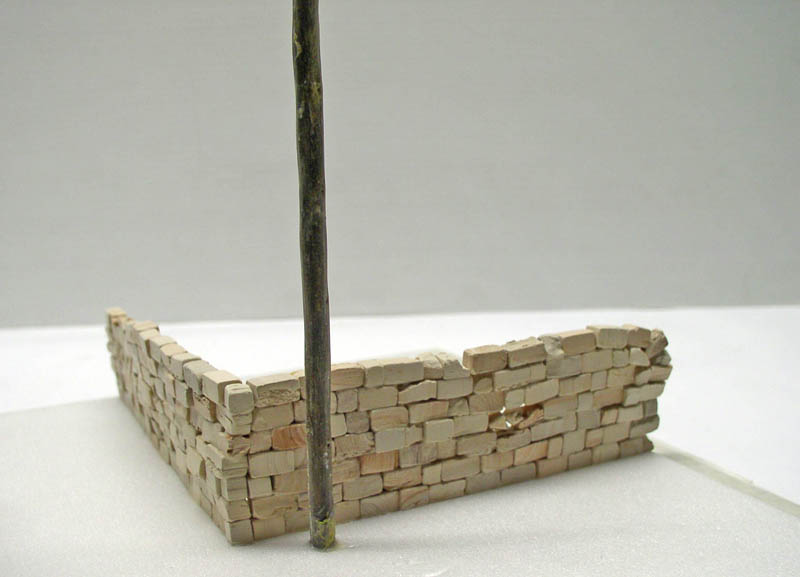 Mur d'angle en briques miniatures construit pour un diorama de maquettisme avec branche