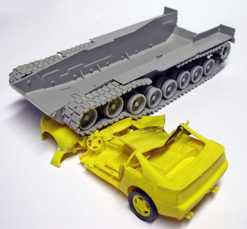 Châssis gris à chenilles de l'Abrams M1A1 écrasant une maquette de voiture jaune