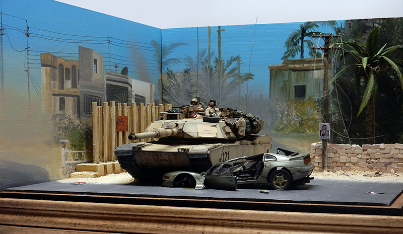 Diorama d'un Abrams M1 A1 en rue irakienne, épave de voiture et décor peint