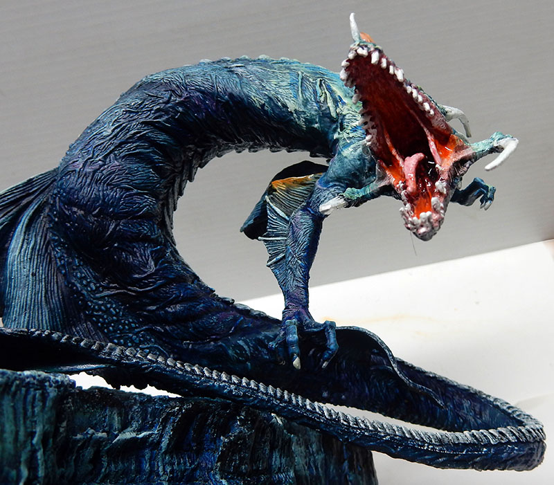 Maquette de créature abyssale bleue gueule ouverte rouge sur socle rocheux