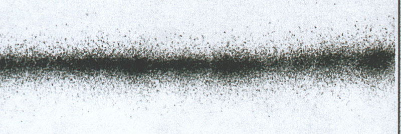 Trait horizontal flou pulvérisé à l'aérographe montrant la dispersion granuleuse de la peinture