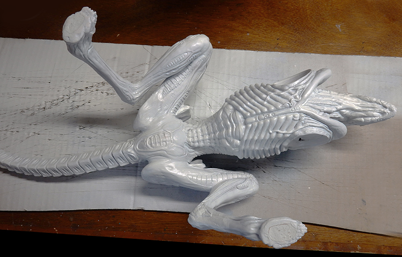 Maquette du xénomorphe Alien 3 en apprêt gris clair, posée sur un plan de travail