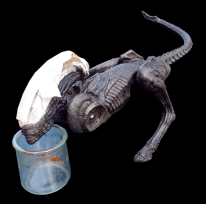 Maquette de xénomorphe Alien 3 en cours de peinture, tête posée sur un pot en verre