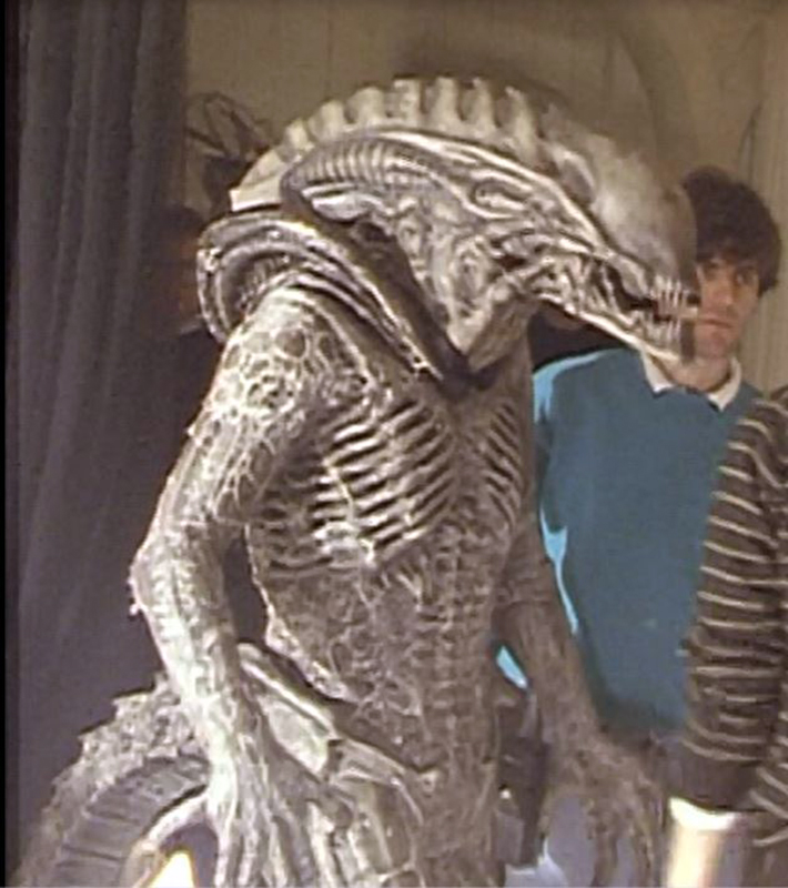 Maquette grandeur nature du xénomorphe d'Alien 3 à côté d'un technicien sur le plateau
