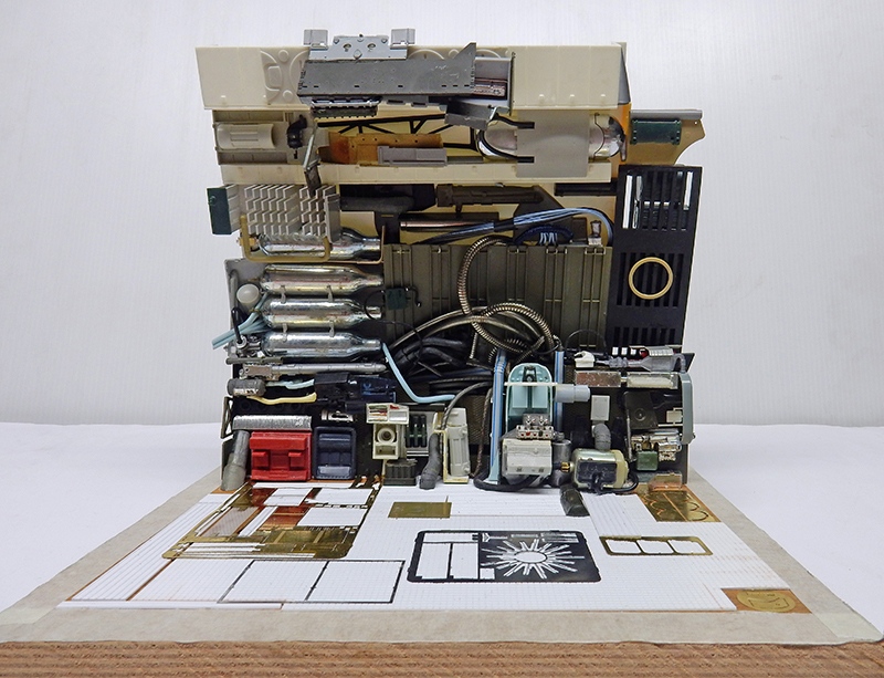 Maquette d'un mur technique de vaisseau avec tuyaux, câbles et pièces détaillées, plaque de photodécoupe au sol