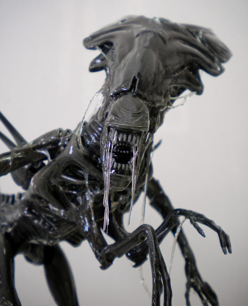 Gros plan de la tête de la reine Alien peinte, bave translucide dégoulinant des mâchoires