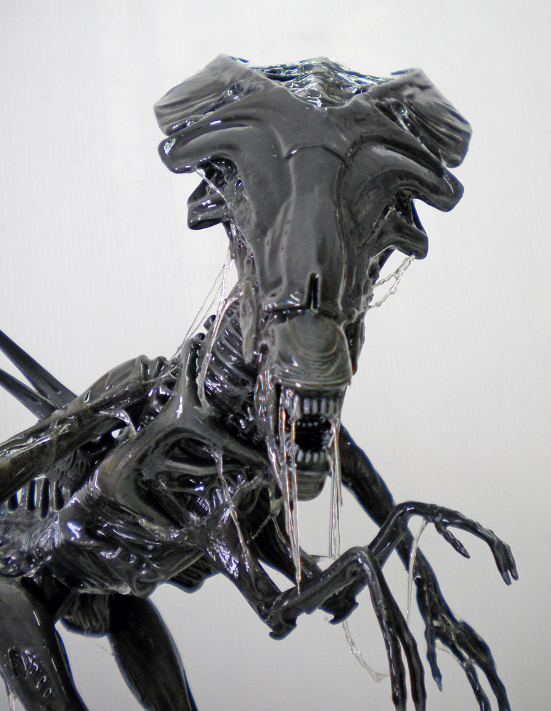 Gros plan de la tête de la reine Alien peinte en noir laqué, bave filante