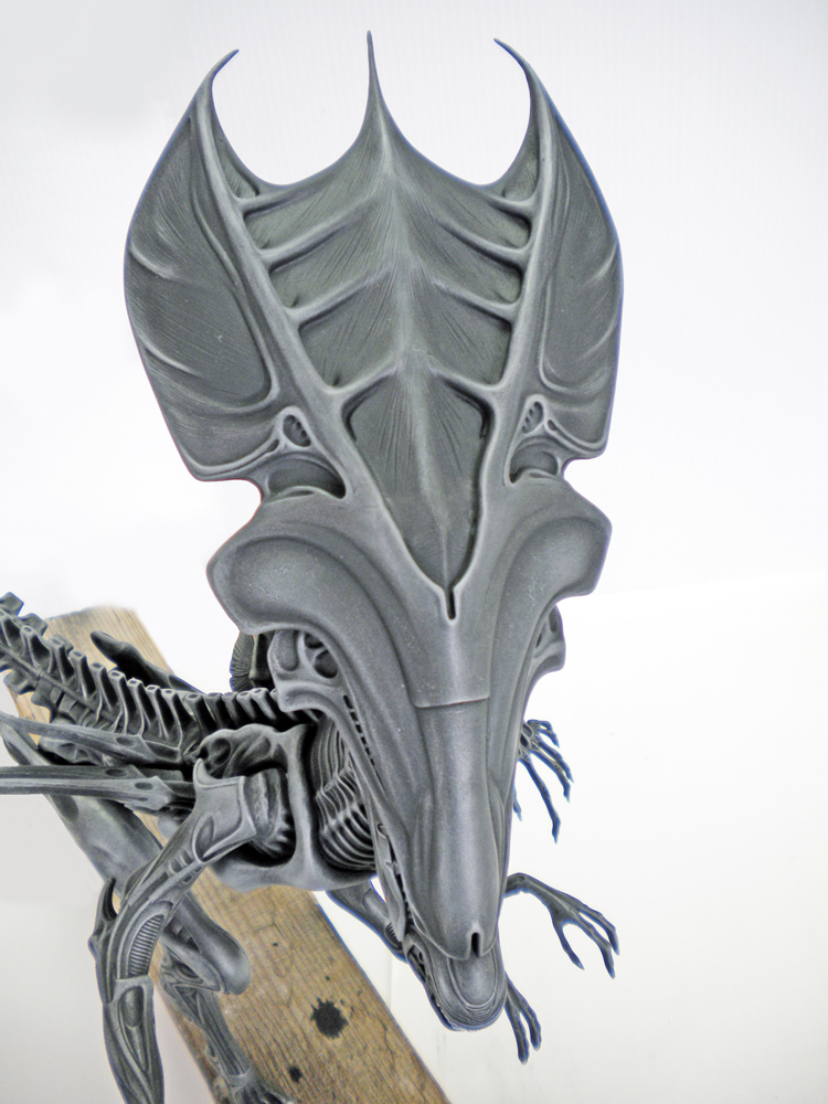 Tête et crête de la maquette reine Alien grise en cours de montage sur support bois