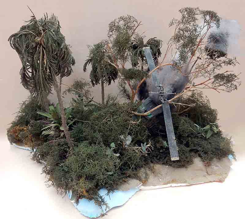 Diorama de jungle avec palmiers et hélicoptère militaire écrasé émergeant de la végétation tropicale dense