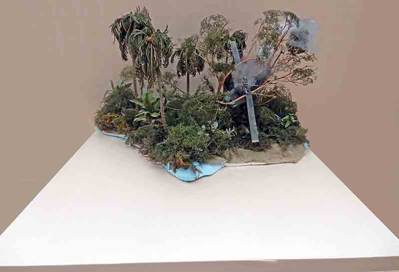 Diorama de jungle tropicale avec palmiers, rivière et épave fumante d'hélicoptère