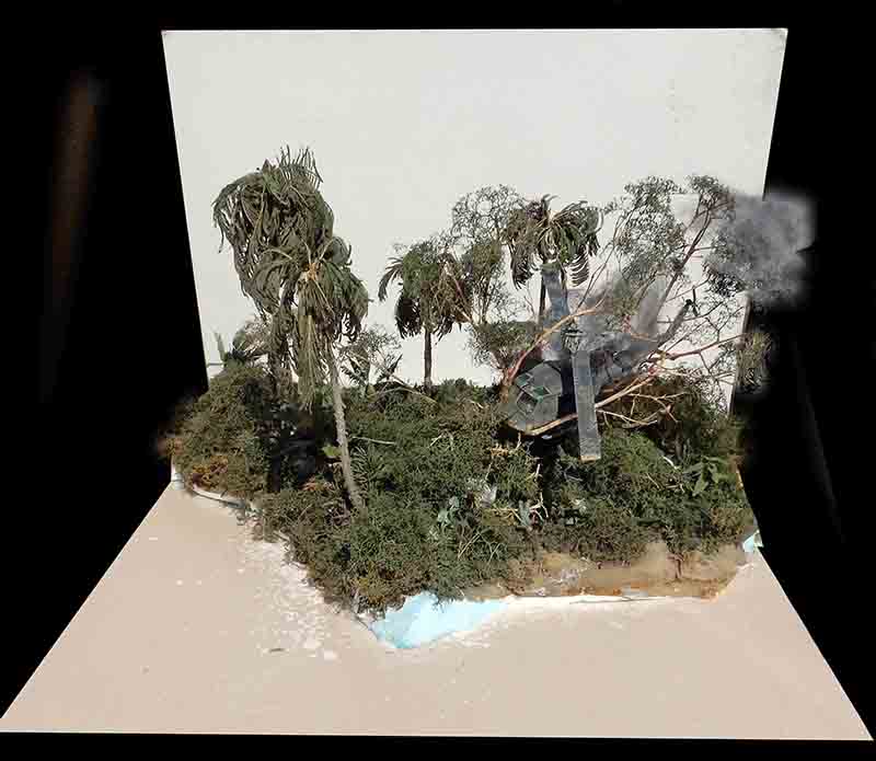 Diorama de jungle tropicale avec hélicoptère écrasé fumant parmi palmiers et végétation dense