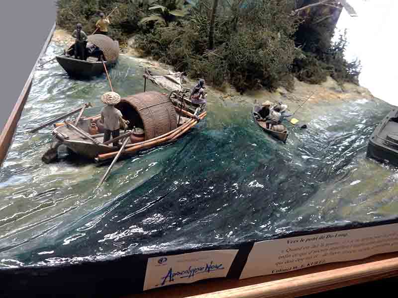Diorama Apocalypse Now avec barques de pêcheurs naviguant sur une rivière agitée bordée de végétation tropicale