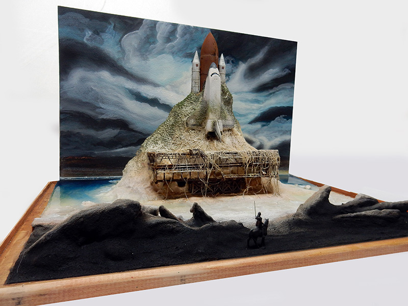 Diorama de maquettisme avec navette spatiale sur un rocher, fond peint en 2D prolongé par un décor 3D