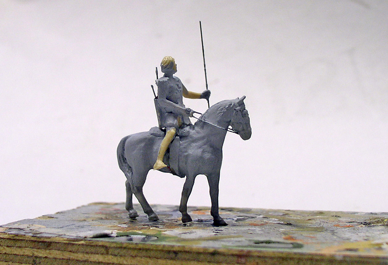 Figurine de cavalier tenant une lance, montée sur un cheval gris en cours de modelage