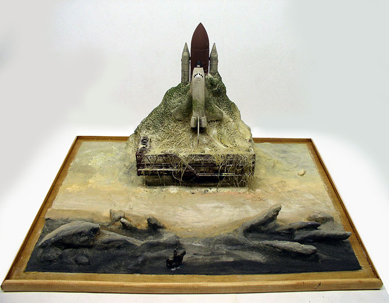 Maquette de navette spatiale dressée sur un diorama rocheux avec cadre en bois