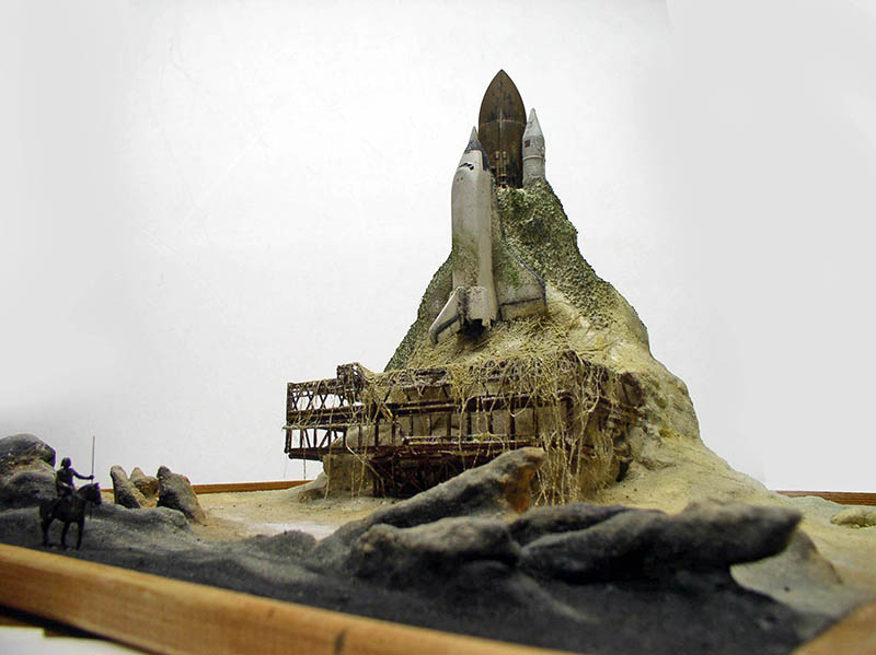 Diorama de maquette avec navette spatiale émergeant d'une montagne rocheuse et cavalier au premier plan