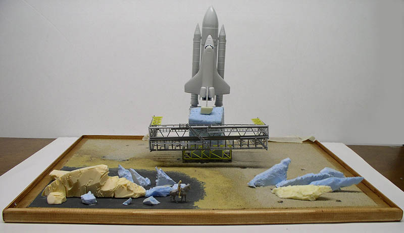 Maquette en cours de montage d'une navette spatiale sur pas de tir avec diorama de roches