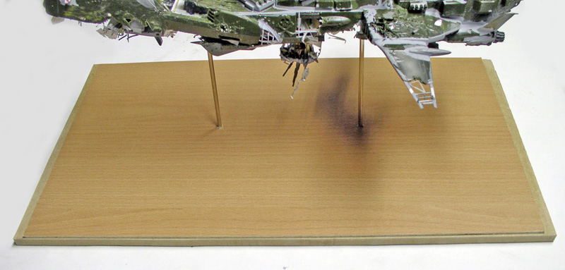 Maquette de l'Arcadia suspendue par des tiges au-dessus d'un socle en bois clair
