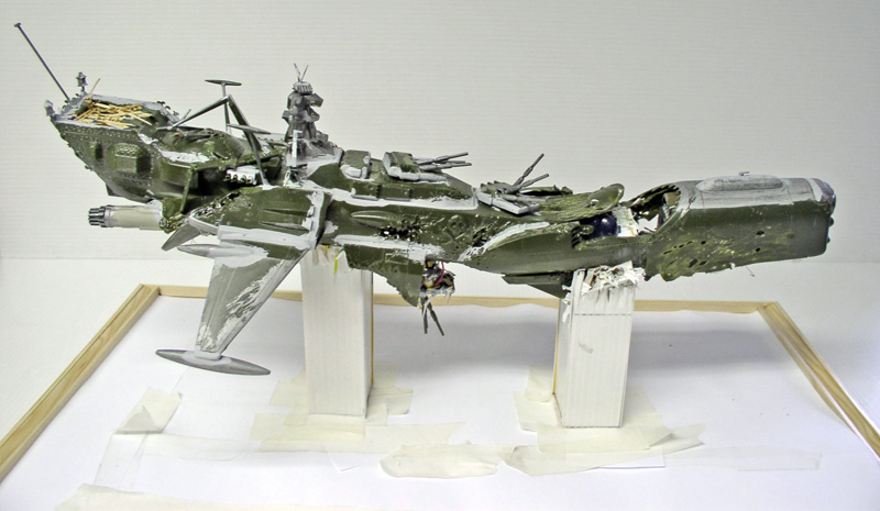 Maquette du vaisseau spatial Arcadia endommagé et accidenté, posée sur supports en cours de construction