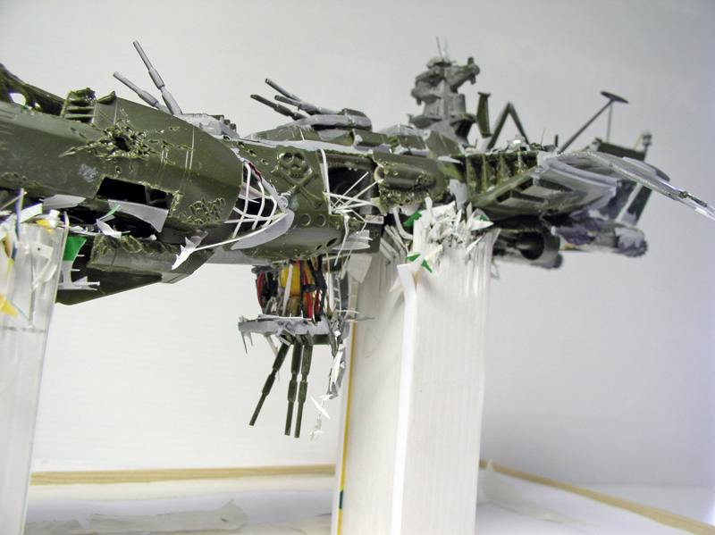 Maquette de l'Arcadia d'Albator en cours de montage, coque verte endommagée avec détails et câblages apparents