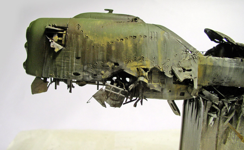 Maquette de la coque verte de l'Arcadia accidenté, fuselage déchiré et noirci par le crash