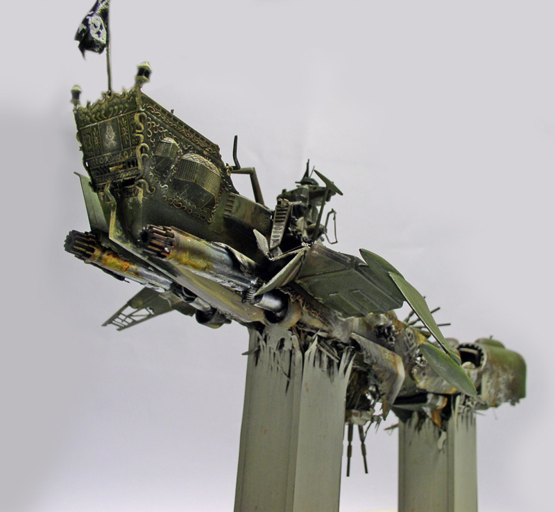 Maquette du cuirassé Arcadia crashé, proue dressée avec drapeau pirate, coque verte endommagée