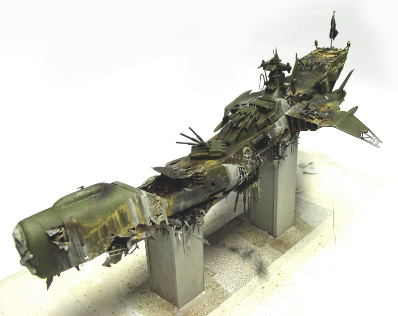 Maquette de l'Arcadia d'Albator crashé, coque verte brisée en deux sur socles