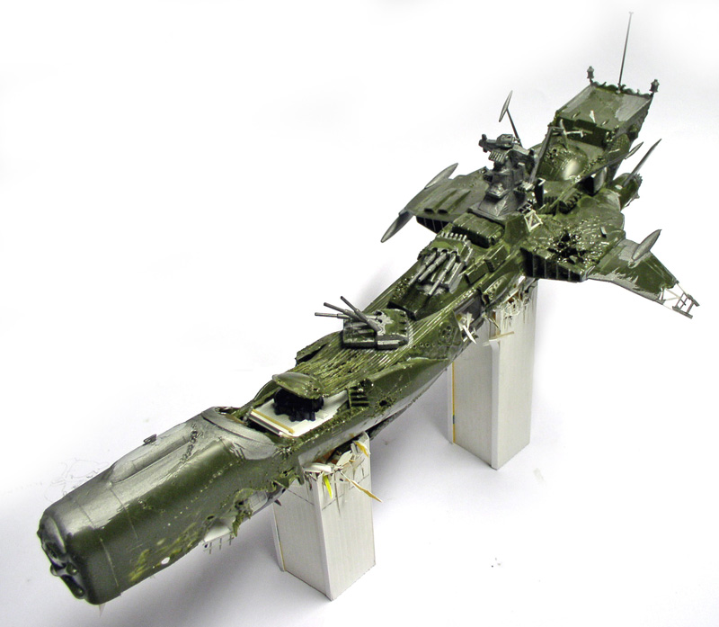 Maquette verte de l'Arcadia d'Albator en cours de montage posée sur deux supports blancs