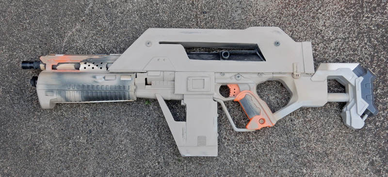 Réplique de fusil futuriste pour cosplay en cours de peinture posée au sol