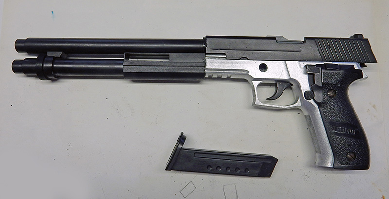 Pistolet de cosplay personnalisé avec long canon et chargeur posé à côté