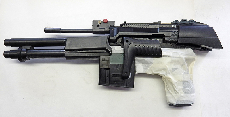 Réplique d'arme de cosplay en cours de fabrication, fusil noir avec pièces assemblées et ruban de masquage
