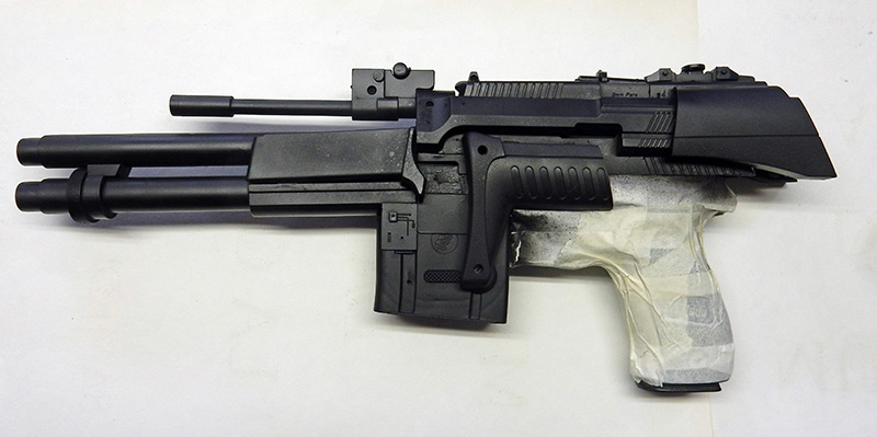 Maquette d'arme de cosplay en cours de fabrication, peinte en noir avec poignée masquée au ruban